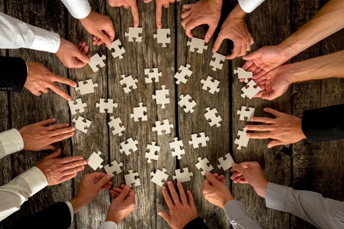 businessmen-hands-holding-puzzle-pieces-on-table-2021-08-26-22-28-00-utc (1)